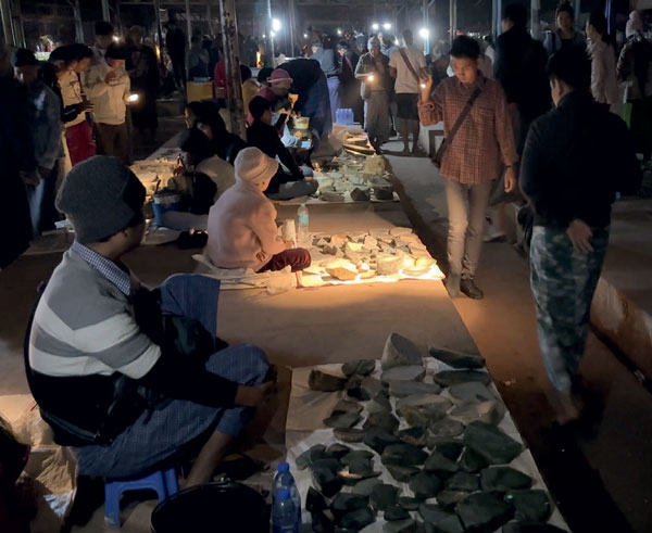Buyers walking through the early morning rough market scanning rough and sawn jadeite with their torches. 
(Photo: Andrew Lucas. ©Guild Gemology Education)