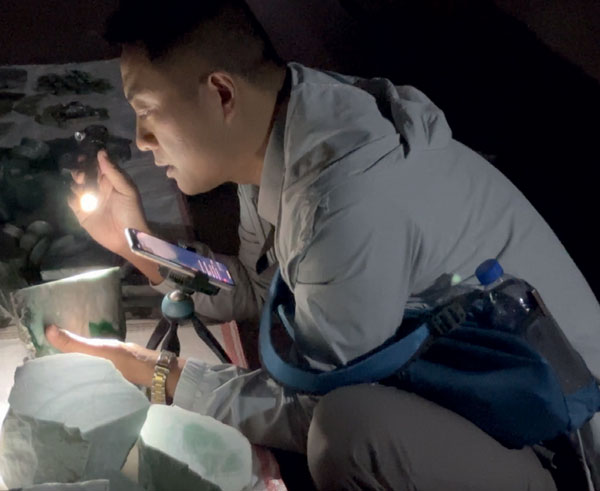 Chinese live-streamer examining rough with his customer over the phone. (Photo: Andrew Lucas. ©Guild Gemology Education)