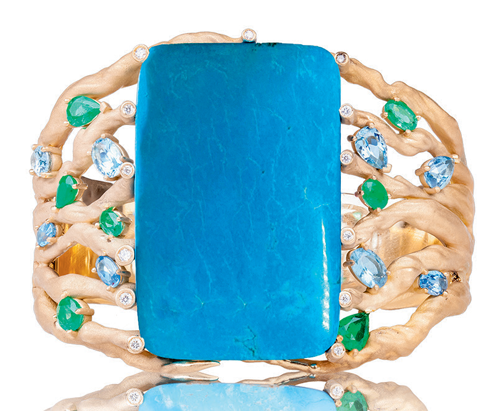 Bangle with turquoise center accented by emeralds and aquamarines in 18K gold.