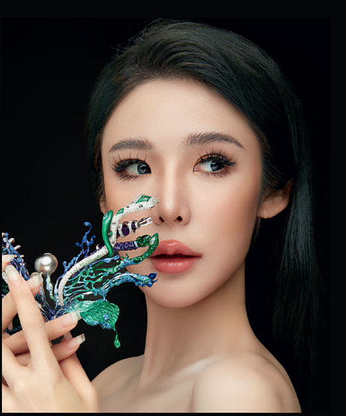 Rain Lee holding her award-winning and mythology-inspired 'Medusa's Secret,' a transformable piece made using a special electro-coating process on gold, with gems and a pearl.